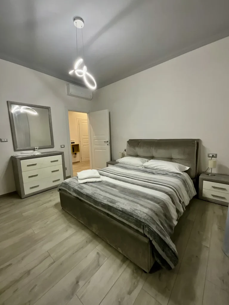 Letto matrimoniale con comodini, cassettiera e aria condizionata